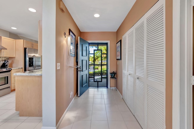 doorway to outside with light tile patterned floors