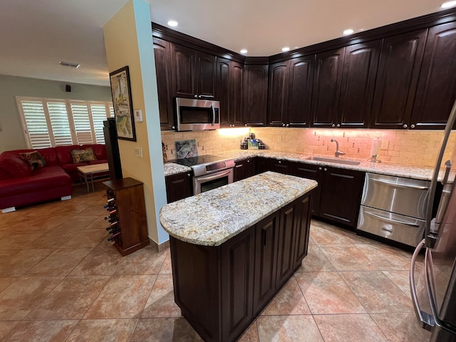 kitchen with a kitchen island, sink, backsplash, dark brown cabinetry, and stainless steel appliances