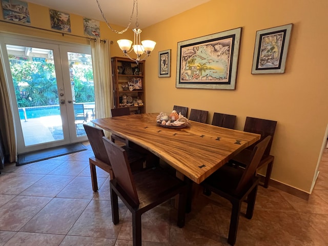 dining room featuring tile patterned floors, an inviting chandelier, and french doors