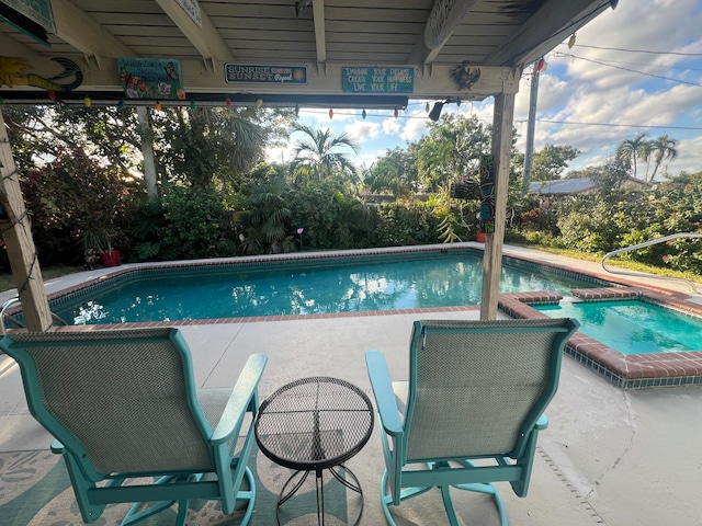 view of pool with an in ground hot tub