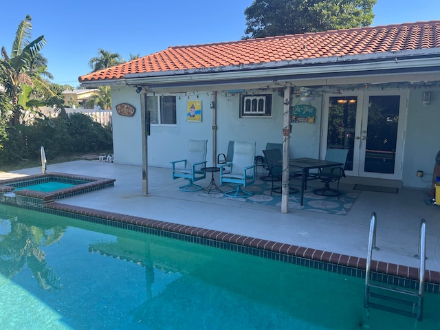 back of house with a pool with hot tub, a patio area, and french doors