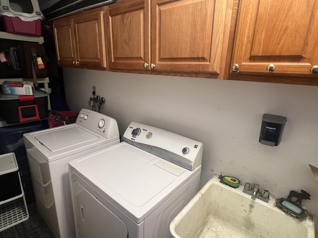 washroom featuring sink, cabinets, and washing machine and clothes dryer