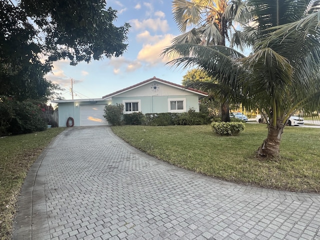 view of front of house with a garage and a yard