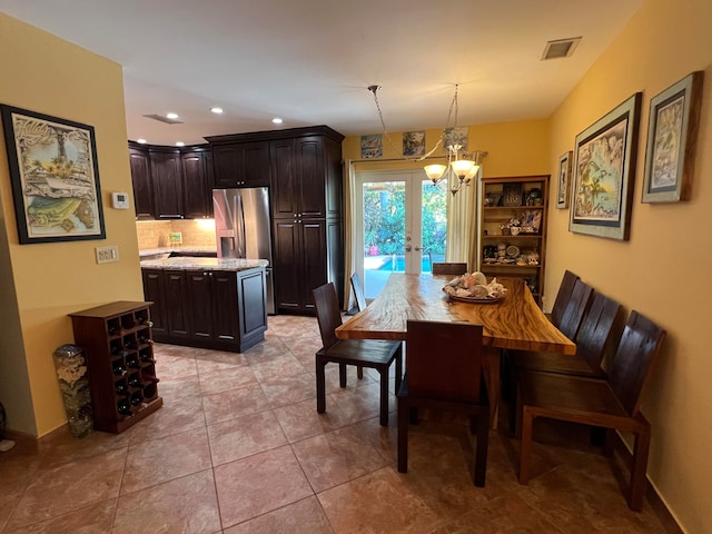 dining space featuring light tile patterned floors, an inviting chandelier, and french doors