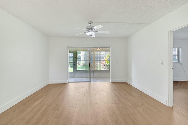 empty room with light wood-style floors, ceiling fan, a textured ceiling, and baseboards