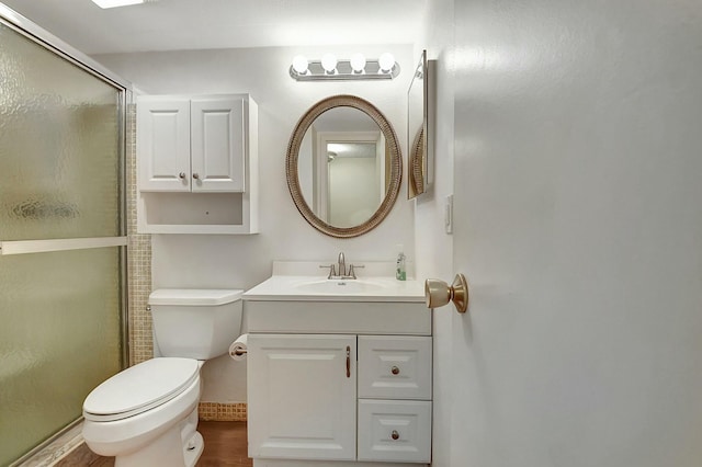 bathroom with a shower with door, vanity, wood-type flooring, and toilet