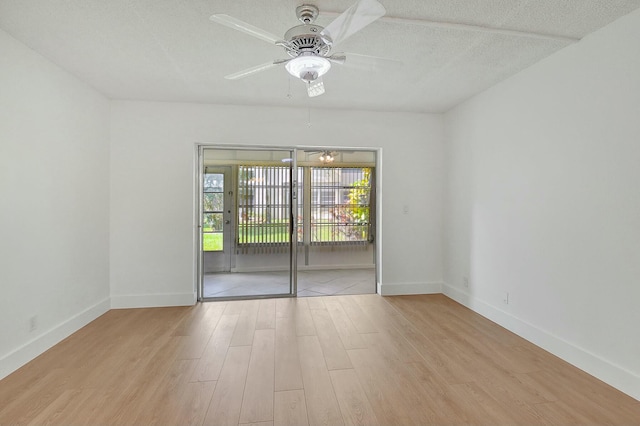 unfurnished room featuring a textured ceiling, ceiling fan, wood finished floors, and baseboards