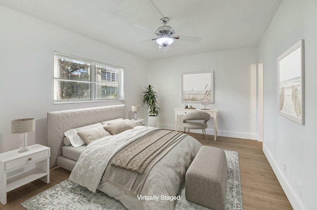 bedroom with ceiling fan, baseboards, and wood finished floors