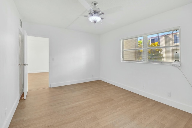 unfurnished room with light wood-style floors, a ceiling fan, baseboards, and a wealth of natural light