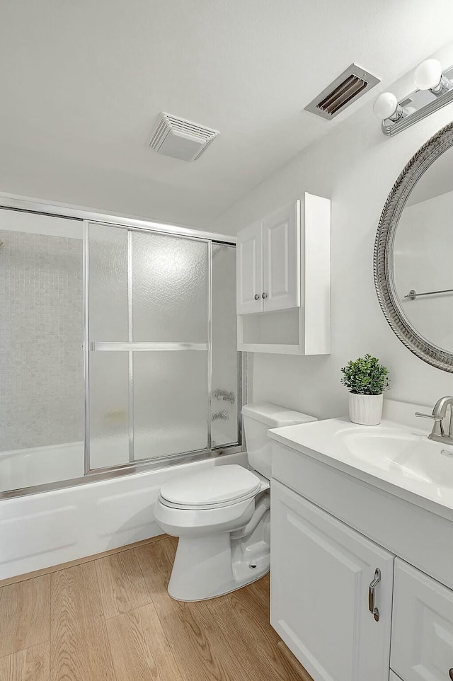 bathroom featuring visible vents, vanity, toilet, and wood finished floors