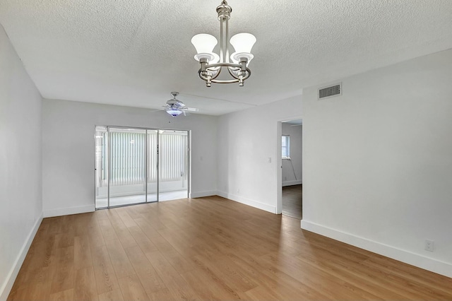 empty room featuring a textured ceiling, ceiling fan with notable chandelier, and hardwood / wood-style flooring