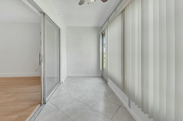 hall featuring light wood-style flooring and baseboards