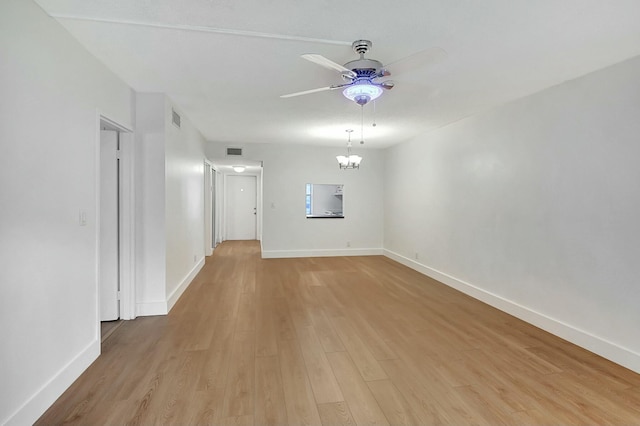 unfurnished room featuring light hardwood / wood-style floors and ceiling fan with notable chandelier