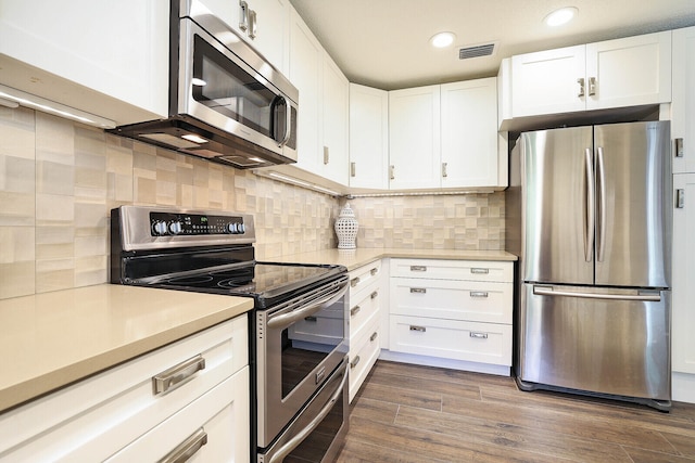 kitchen featuring white cabinets, dark hardwood / wood-style floors, stainless steel appliances, and tasteful backsplash