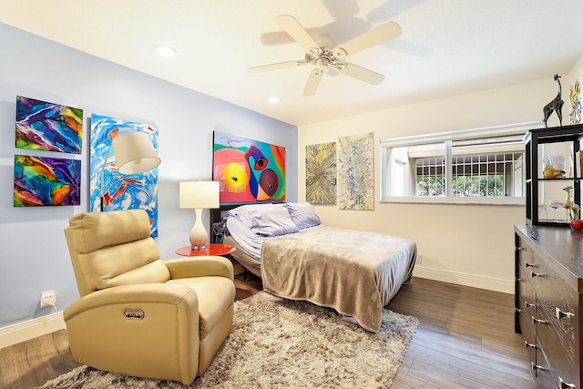 bedroom with dark hardwood / wood-style flooring and ceiling fan