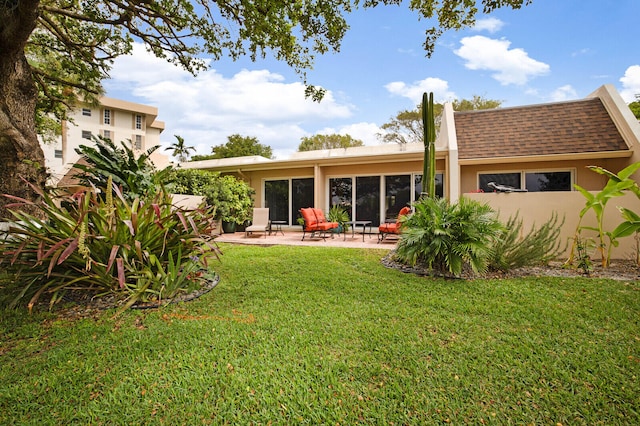 back of house featuring a lawn and a patio