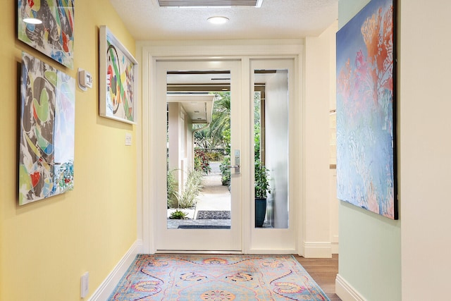 doorway with hardwood / wood-style flooring and a textured ceiling