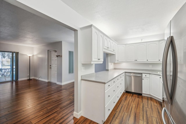 kitchen with a textured ceiling, white cabinetry, stainless steel appliances, and dark wood-type flooring