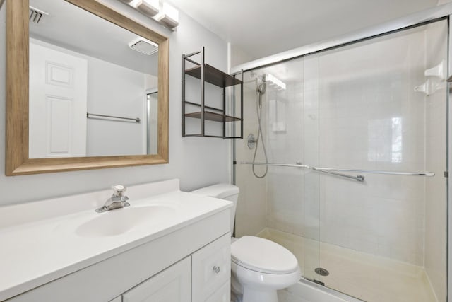 bathroom with vanity, a shower with shower door, and toilet