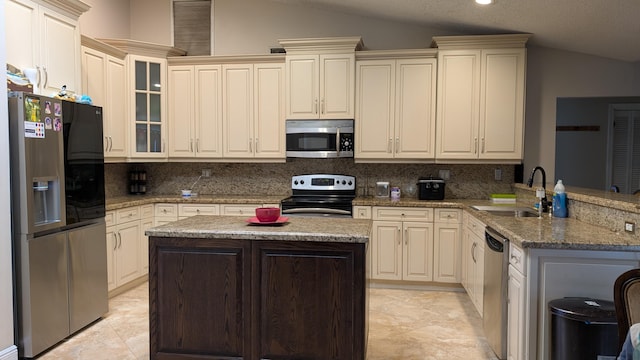 kitchen featuring sink, vaulted ceiling, light stone countertops, kitchen peninsula, and stainless steel appliances