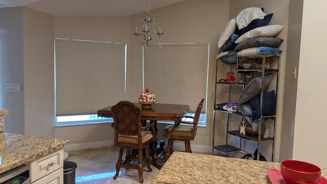 dining area with tile patterned flooring and a notable chandelier