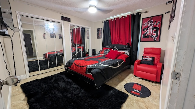 bedroom with multiple closets, ceiling fan, and a textured ceiling