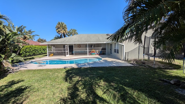 view of pool featuring a sunroom, a trampoline, a patio, and a lawn