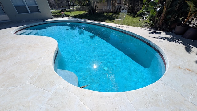 view of swimming pool with a yard