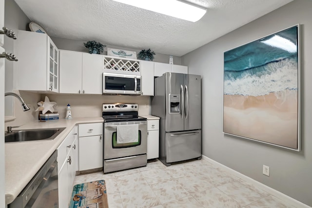 kitchen with white cabinetry, sink, a textured ceiling, and appliances with stainless steel finishes