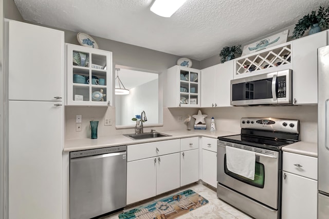 kitchen with a textured ceiling, white cabinetry, sink, and appliances with stainless steel finishes