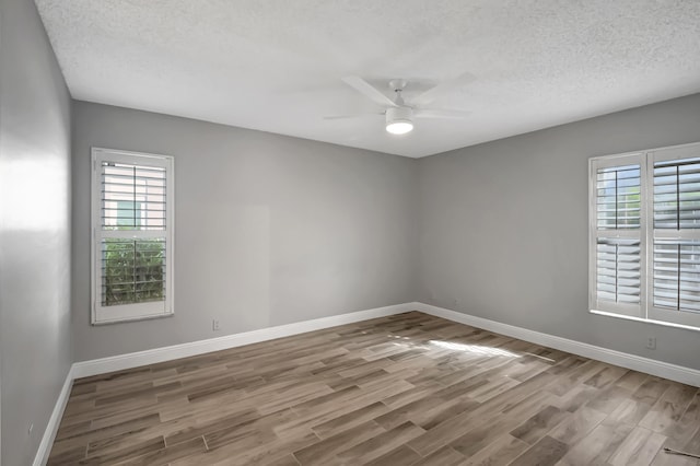 spare room featuring a textured ceiling, light hardwood / wood-style floors, and ceiling fan