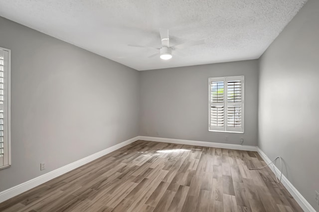 unfurnished room featuring wood-type flooring, a textured ceiling, and ceiling fan