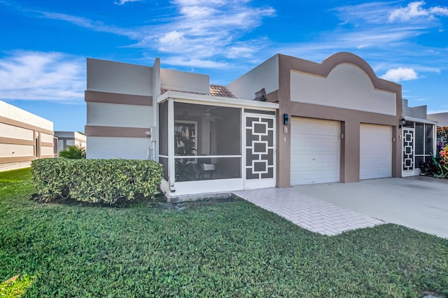 view of front of property with a front yard, a garage, and a sunroom