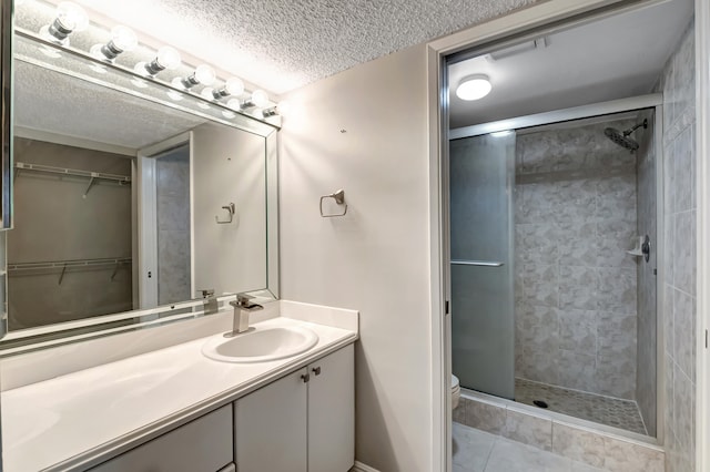 bathroom featuring vanity, tile patterned floors, toilet, a textured ceiling, and a shower with shower door