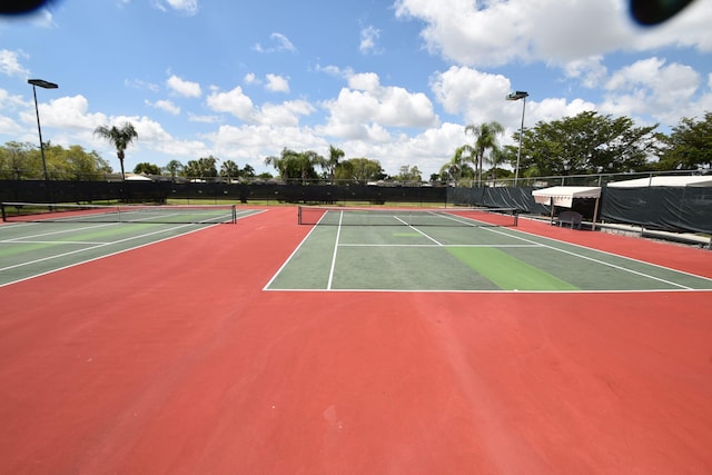 view of tennis court featuring basketball hoop