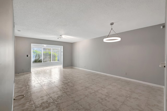 unfurnished room with a textured ceiling