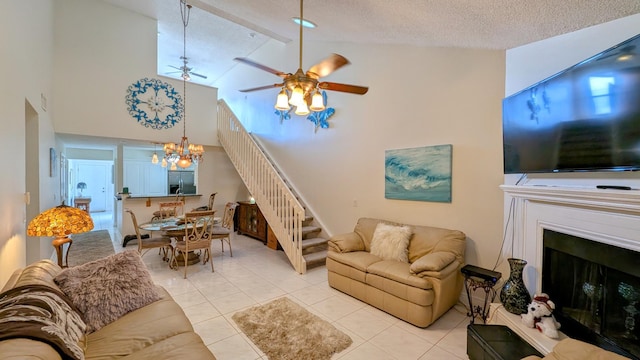 tiled living room with high vaulted ceiling, ceiling fan with notable chandelier, and a textured ceiling