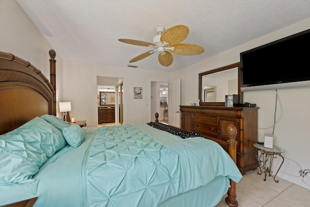 bedroom featuring ceiling fan, light tile patterned flooring, ensuite bathroom, and a textured ceiling