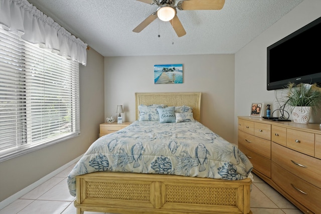 bedroom featuring a textured ceiling, ceiling fan, and light tile patterned flooring