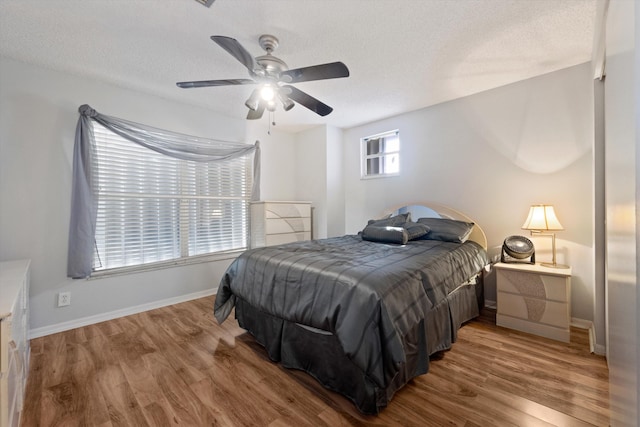 bedroom featuring hardwood / wood-style flooring, ceiling fan, and a textured ceiling