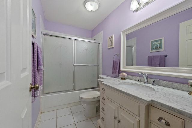 full bathroom with tile patterned flooring, vanity, enclosed tub / shower combo, and toilet