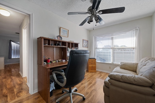 office space with ceiling fan, light hardwood / wood-style flooring, and a textured ceiling