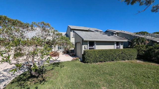 view of property exterior featuring a garage and a lawn