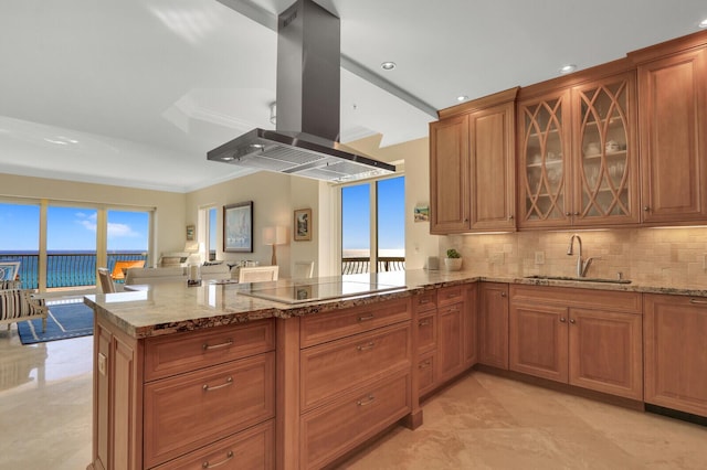 kitchen with sink, light stone counters, island exhaust hood, kitchen peninsula, and black electric stovetop