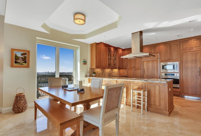 dining room with a raised ceiling and ornamental molding