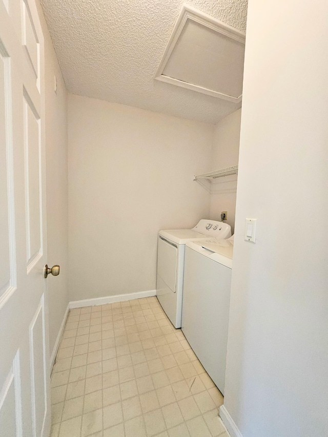 laundry room with light tile patterned flooring, a textured ceiling, and independent washer and dryer