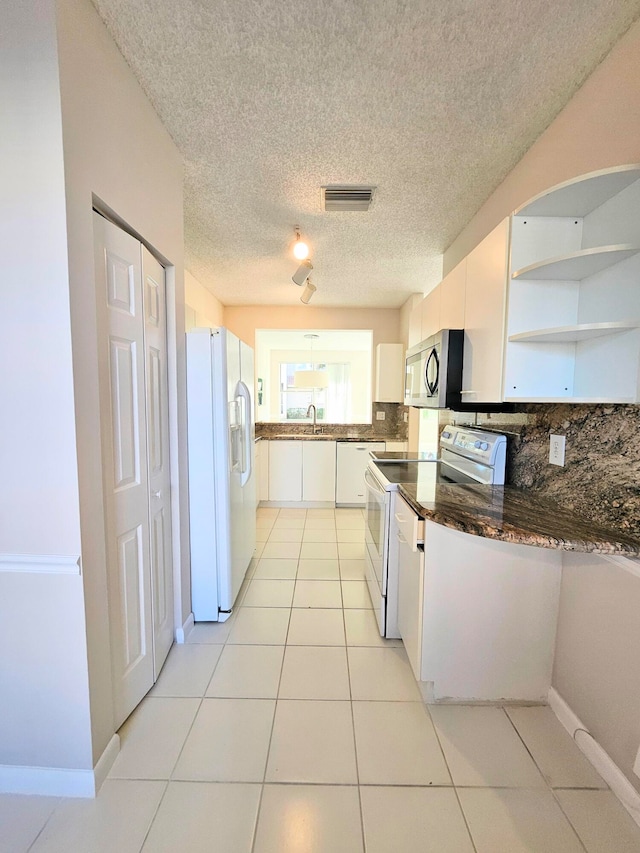 kitchen with white appliances, sink, light tile patterned floors, tasteful backsplash, and white cabinetry