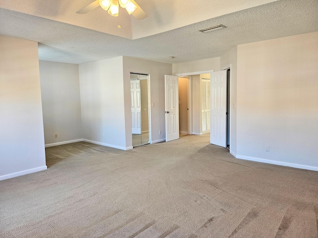 carpeted empty room with ceiling fan and a textured ceiling