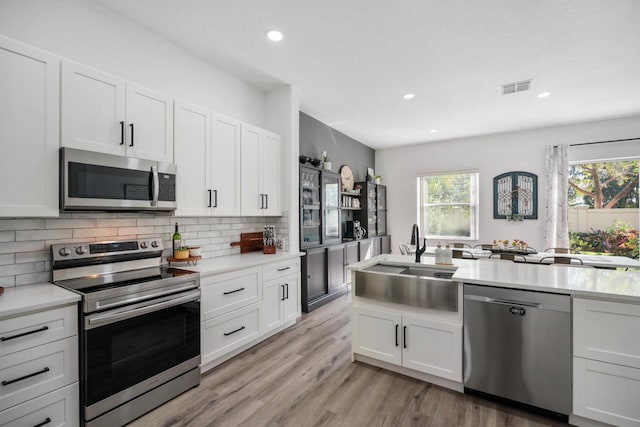 kitchen featuring white cabinetry, sink, tasteful backsplash, and stainless steel appliances