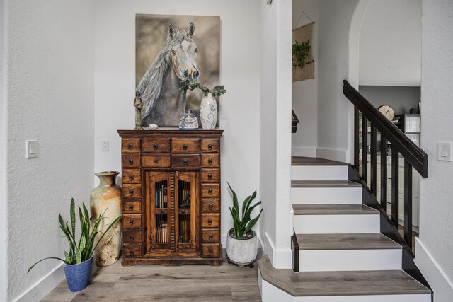 475 Gazetta Way, West Palm Beach, FL 33413 - stairway with arched walkways, wood finished floors, baseboards, and a textured wall